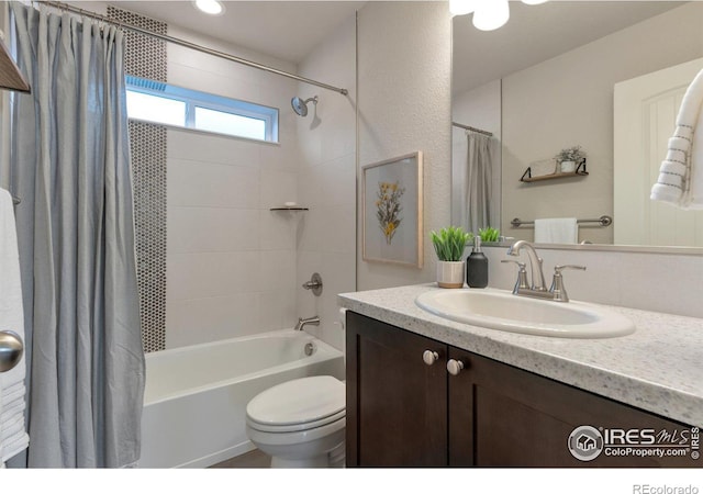 bathroom featuring vanity, toilet, and shower / tub combo with curtain