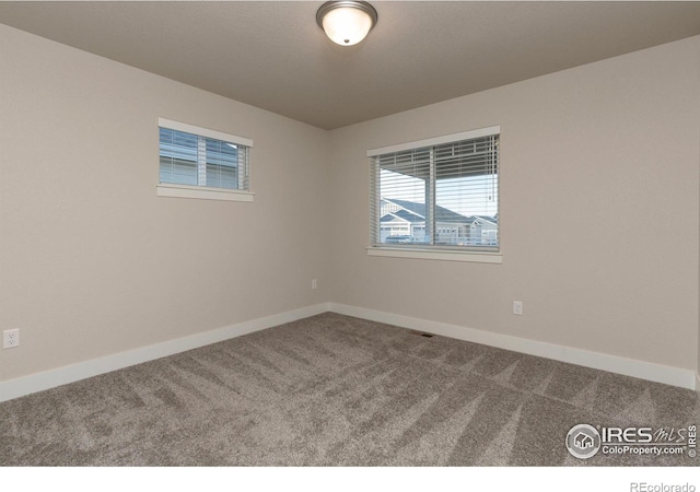 carpeted spare room with baseboards