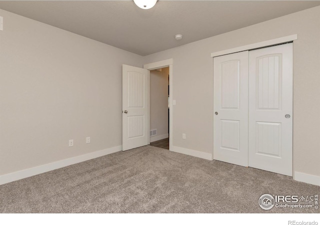 unfurnished bedroom with a closet, baseboards, visible vents, and carpet flooring