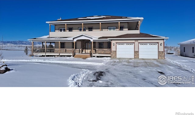 view of front of property with stone siding, a balcony, and a porch