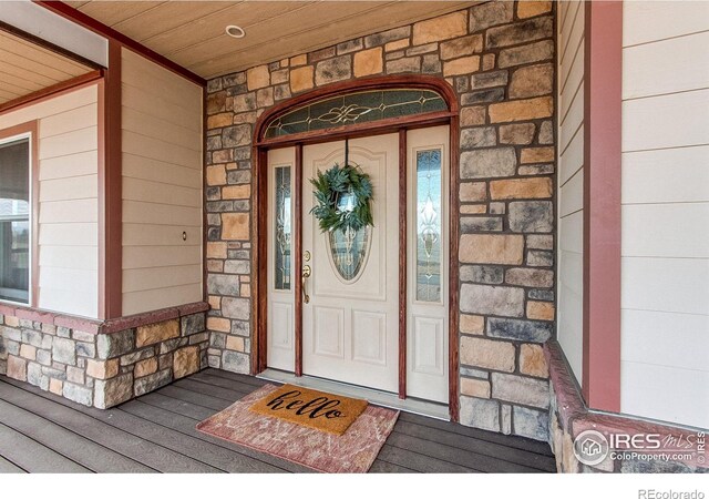 doorway to property featuring stone siding