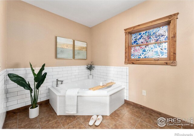 bathroom featuring tile patterned floors, a garden tub, and a healthy amount of sunlight