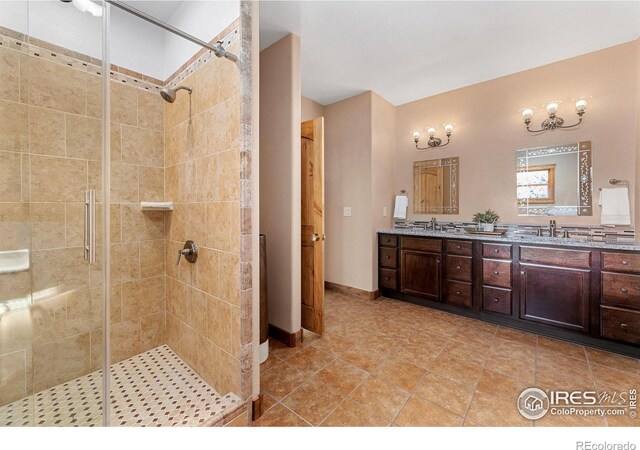 full bathroom with double vanity, a shower stall, and a sink