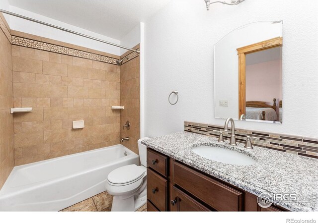 ensuite bathroom featuring vanity, washtub / shower combination, toilet, backsplash, and connected bathroom