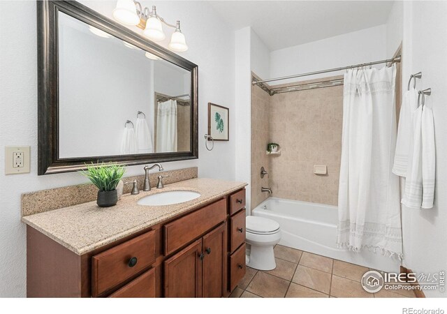 full bath featuring tile patterned floors, toilet, vanity, and shower / tub combo