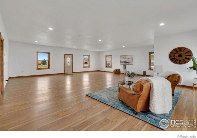 living room with recessed lighting, baseboards, and wood finished floors