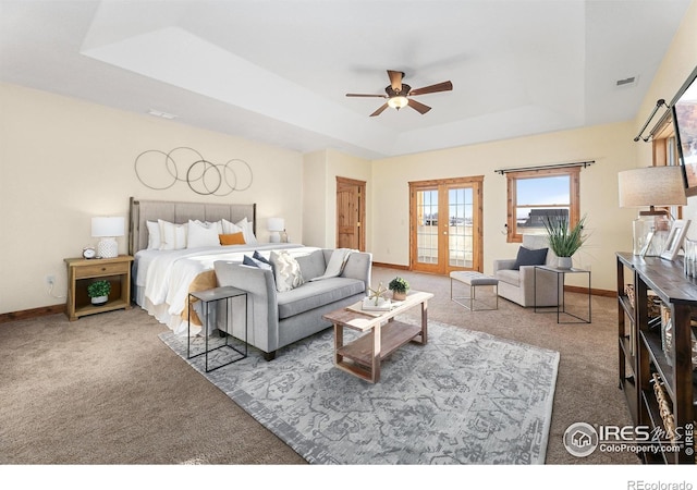 carpeted bedroom with a tray ceiling, access to outside, baseboards, and visible vents