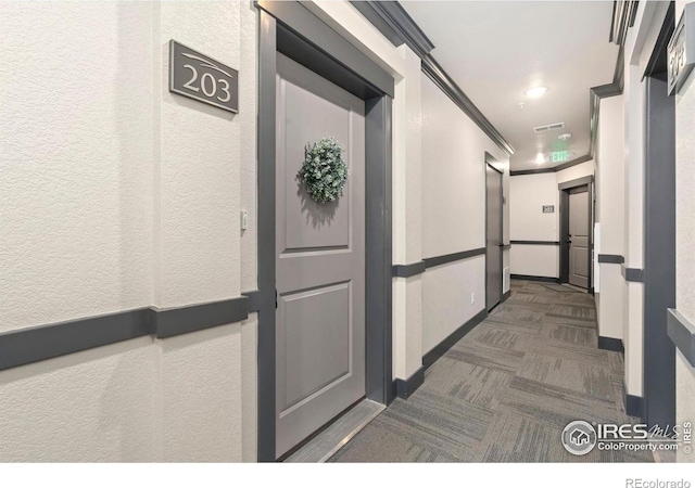 hallway with crown molding, baseboards, carpet floors, recessed lighting, and a textured wall