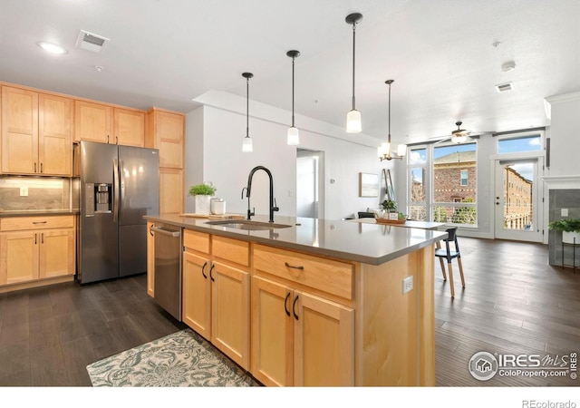 kitchen featuring a sink, stainless steel appliances, dark wood finished floors, and light brown cabinetry