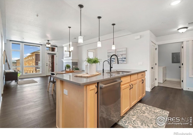 kitchen with light brown cabinets, dark wood finished floors, a center island with sink, stainless steel dishwasher, and a sink