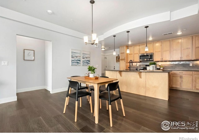 dining space with visible vents, baseboards, dark wood-type flooring, and a chandelier