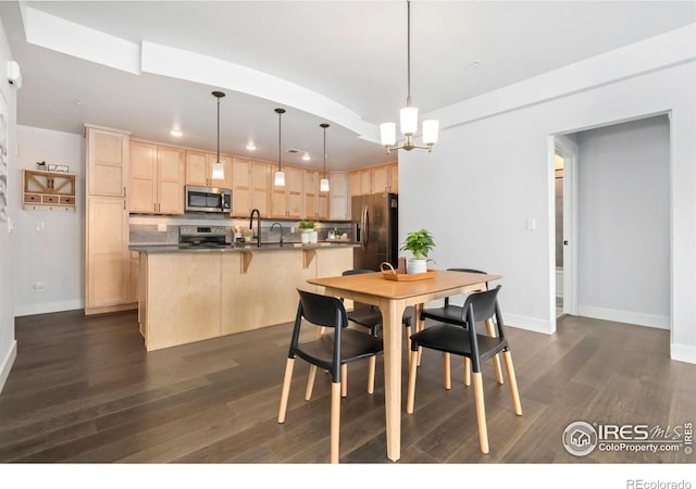 dining room featuring baseboards, a notable chandelier, and dark wood finished floors