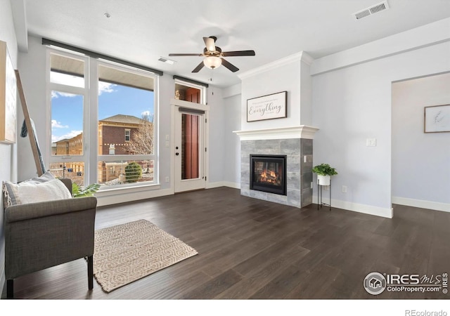 unfurnished living room with baseboards, wood finished floors, visible vents, and a tile fireplace