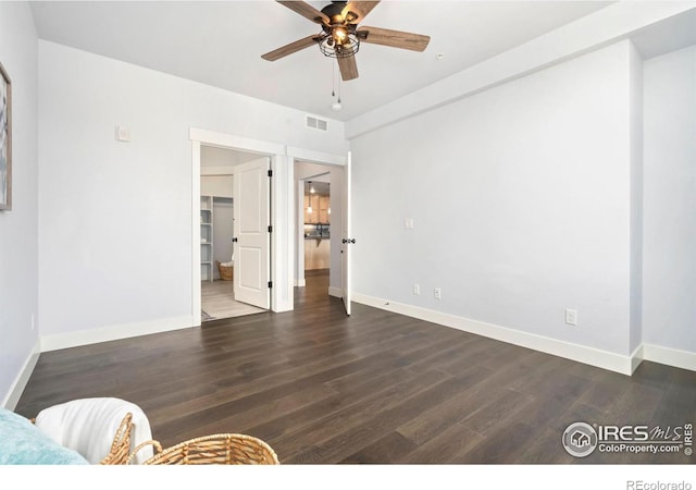 bedroom with visible vents, a ceiling fan, wood finished floors, baseboards, and a spacious closet