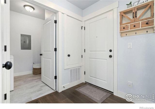 foyer entrance featuring electric panel, wood finished floors, visible vents, and baseboards