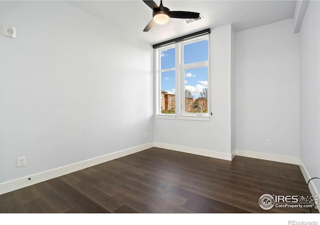 unfurnished room featuring baseboards, dark wood-style flooring, and ceiling fan