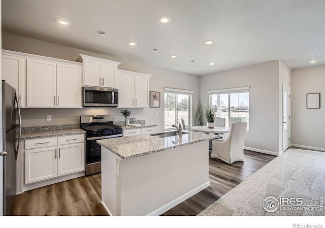 143 Robin Rd, Johnstown, CO 80534 - kitchen with light stone countertops, recessed lighting, appliances with stainless steel finishes, white cabinetry, and a sink