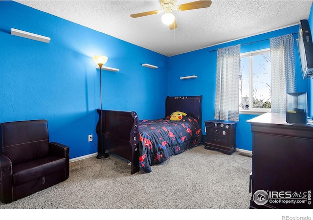 bedroom with baseboards, carpet flooring, a textured ceiling, and a ceiling fan