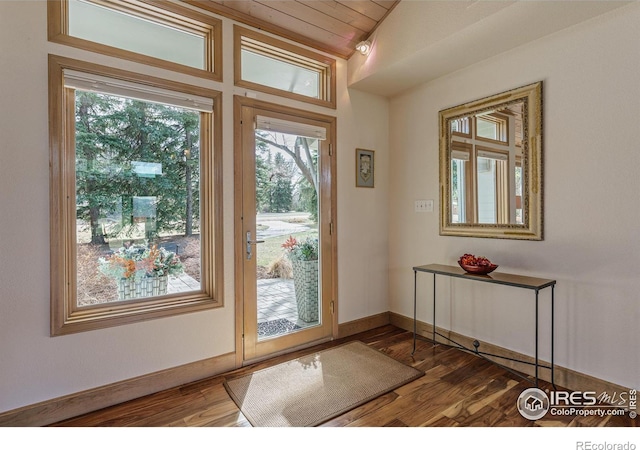 entryway with baseboards, lofted ceiling, and wood finished floors