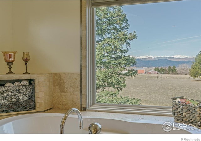 bathroom featuring a bathing tub and a mountain view