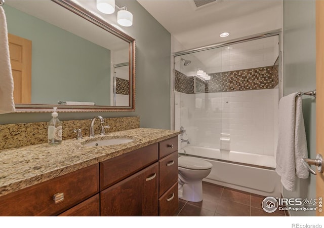 bathroom with shower / bath combination with glass door, toilet, vanity, and tile patterned flooring