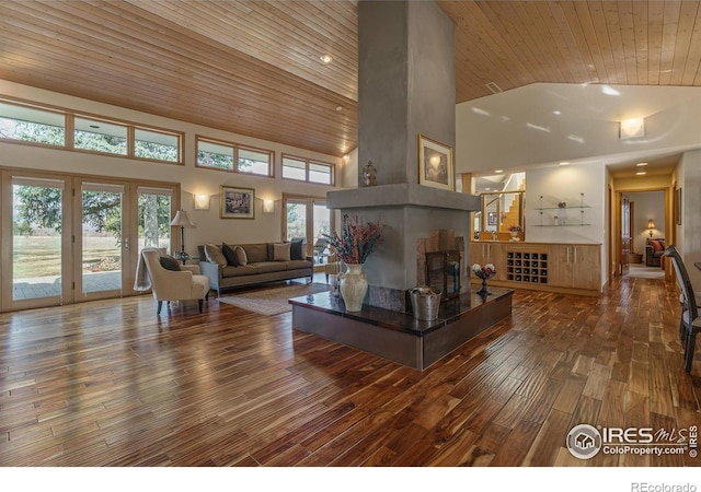 living area featuring wooden ceiling, french doors, a fireplace, wood finished floors, and high vaulted ceiling