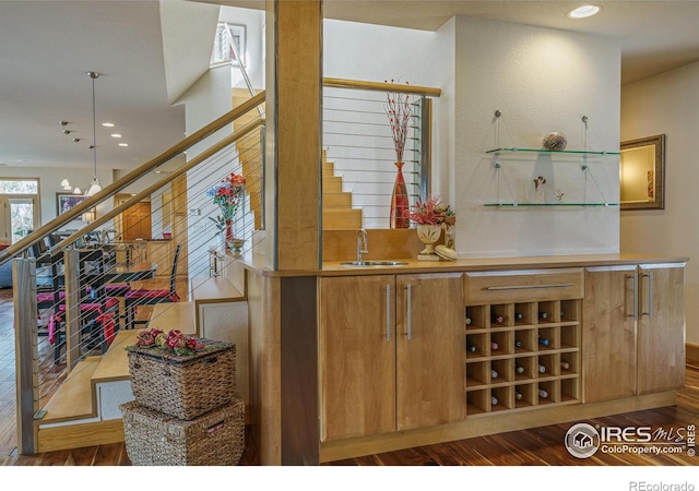 bar featuring stairway, wood finished floors, recessed lighting, a sink, and pendant lighting