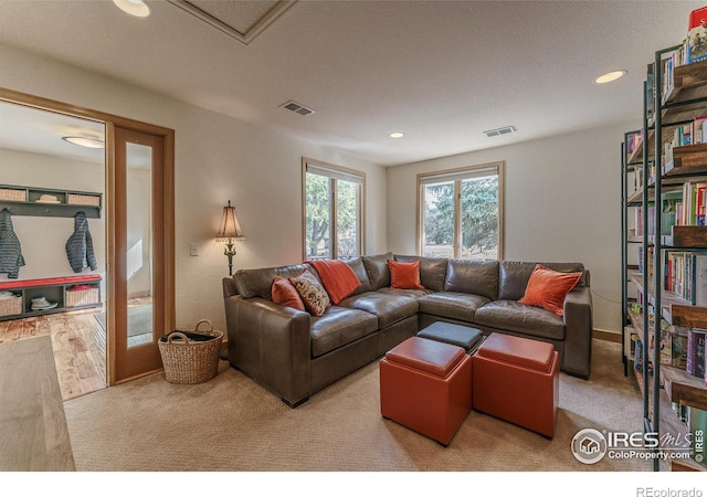 living area with visible vents, recessed lighting, and carpet