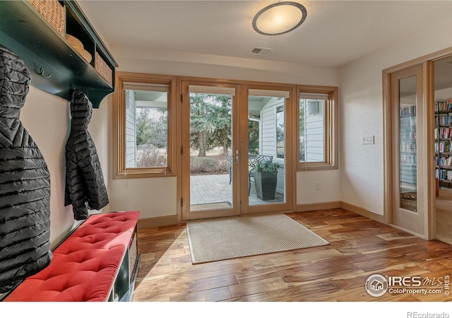 doorway with wood finished floors, french doors, and baseboards