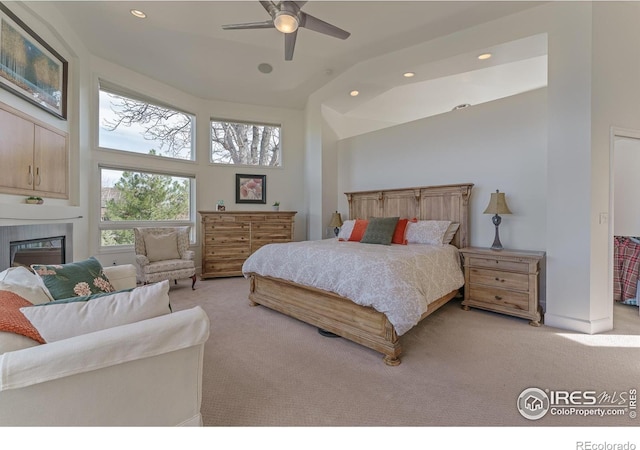 carpeted bedroom featuring recessed lighting, a ceiling fan, high vaulted ceiling, and a tiled fireplace