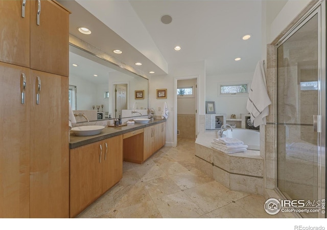 full bathroom featuring a bath, recessed lighting, double vanity, and a sink