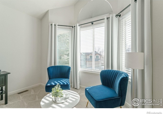 sitting room featuring vaulted ceiling, carpet, visible vents, and baseboards