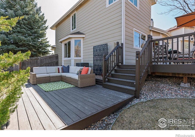 wooden terrace with an outdoor living space and fence