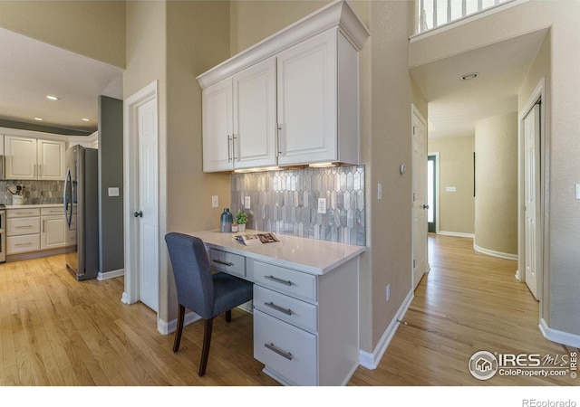 kitchen with white cabinetry, light wood-style floors, and appliances with stainless steel finishes