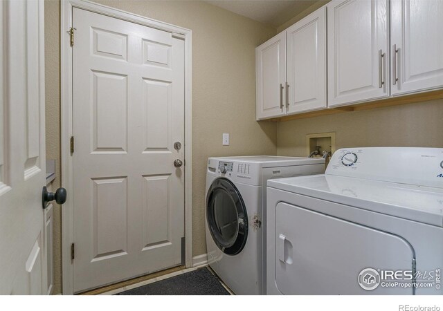 clothes washing area featuring cabinet space and separate washer and dryer