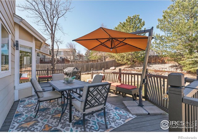 deck featuring area for grilling, outdoor dining area, and fence