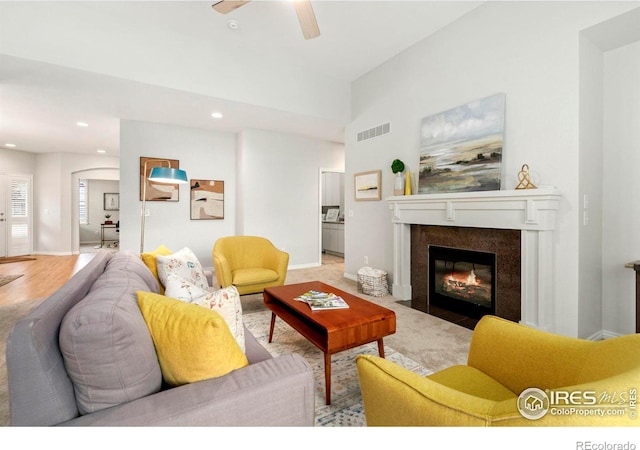 living room featuring visible vents, baseboards, and a tile fireplace