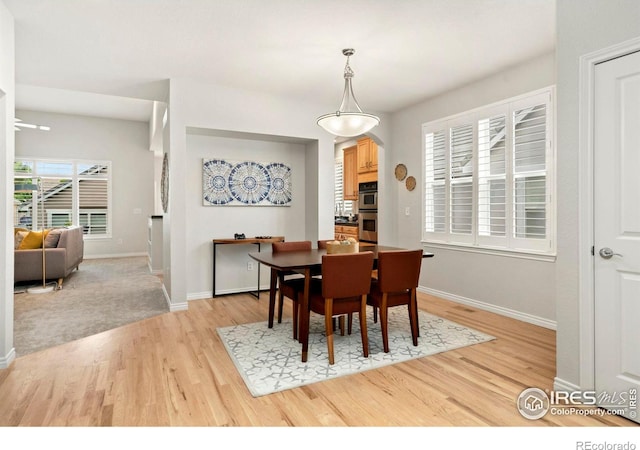 dining area with baseboards and light wood-type flooring