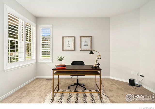 carpeted office space featuring visible vents and baseboards