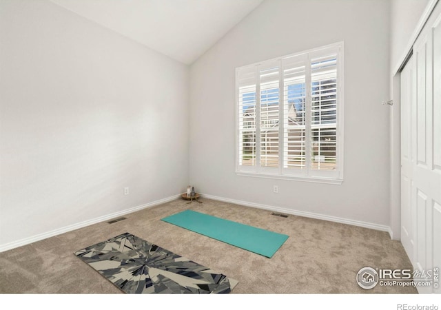 workout room with baseboards, lofted ceiling, carpet, and visible vents