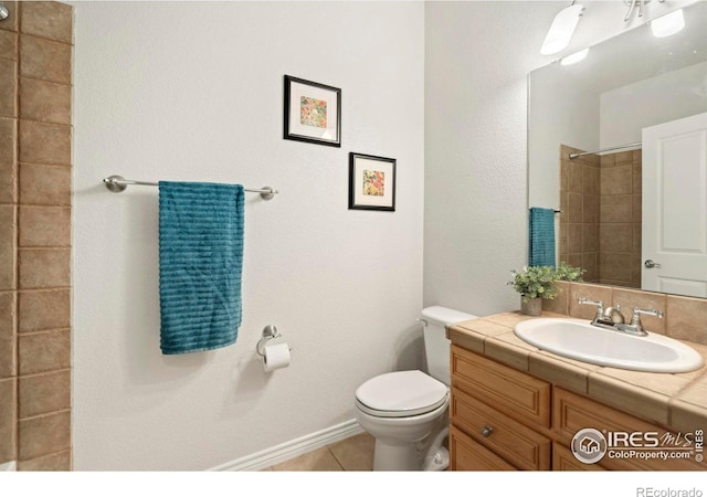 bathroom featuring tile patterned flooring, baseboards, toilet, vanity, and a shower