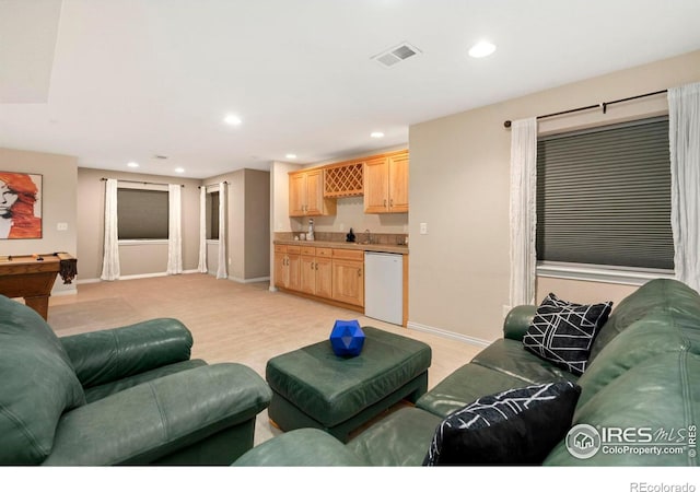 living area with visible vents, baseboards, light colored carpet, recessed lighting, and wet bar