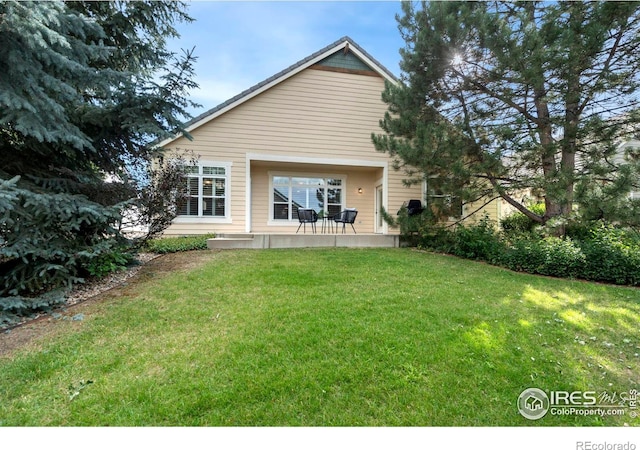 back of house featuring a patio area and a lawn