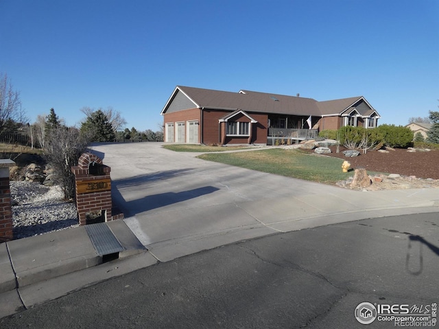 single story home with concrete driveway and a front lawn