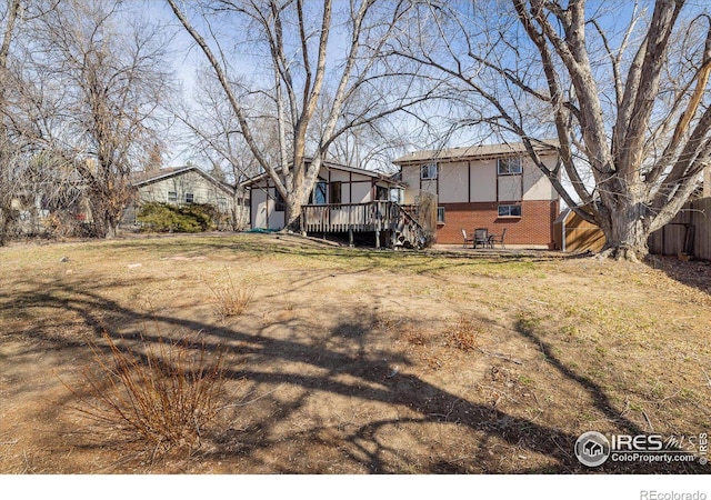 view of yard featuring a deck and fence