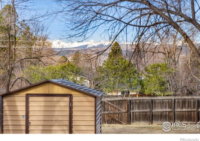 view of shed with fence and a mountain view