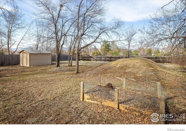 view of yard featuring an outdoor structure, a fenced backyard, and a shed