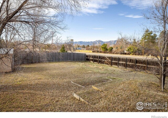 view of yard with a mountain view and fence