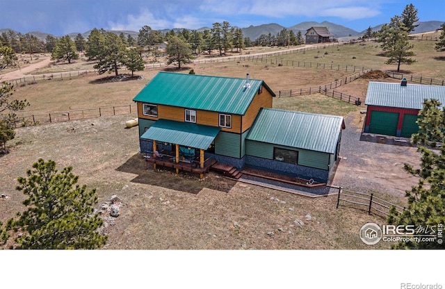 view of front of property featuring a mountain view, a rural view, metal roof, and fence