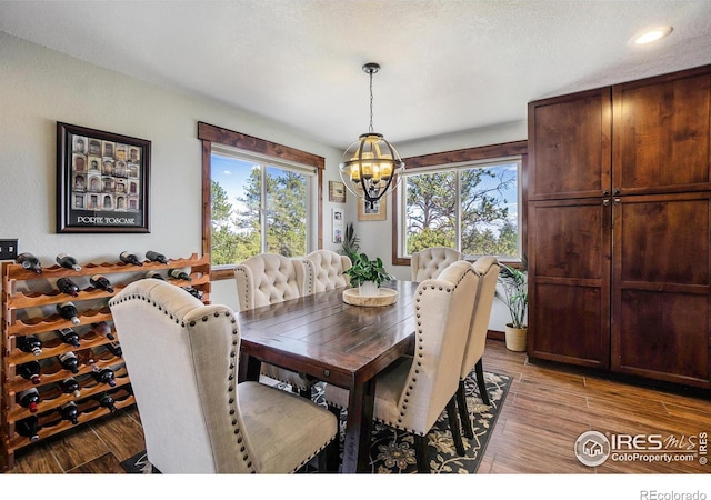 dining room with an inviting chandelier, plenty of natural light, and light wood-style floors